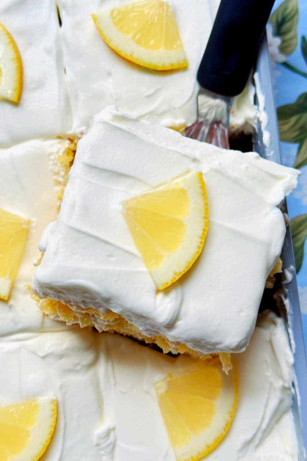 You'll never know this lemon poke cake recipe starts with boxed cake mix. Tender cake topped with lemon glaze and cream cheese frosting. via @foodtasticmom