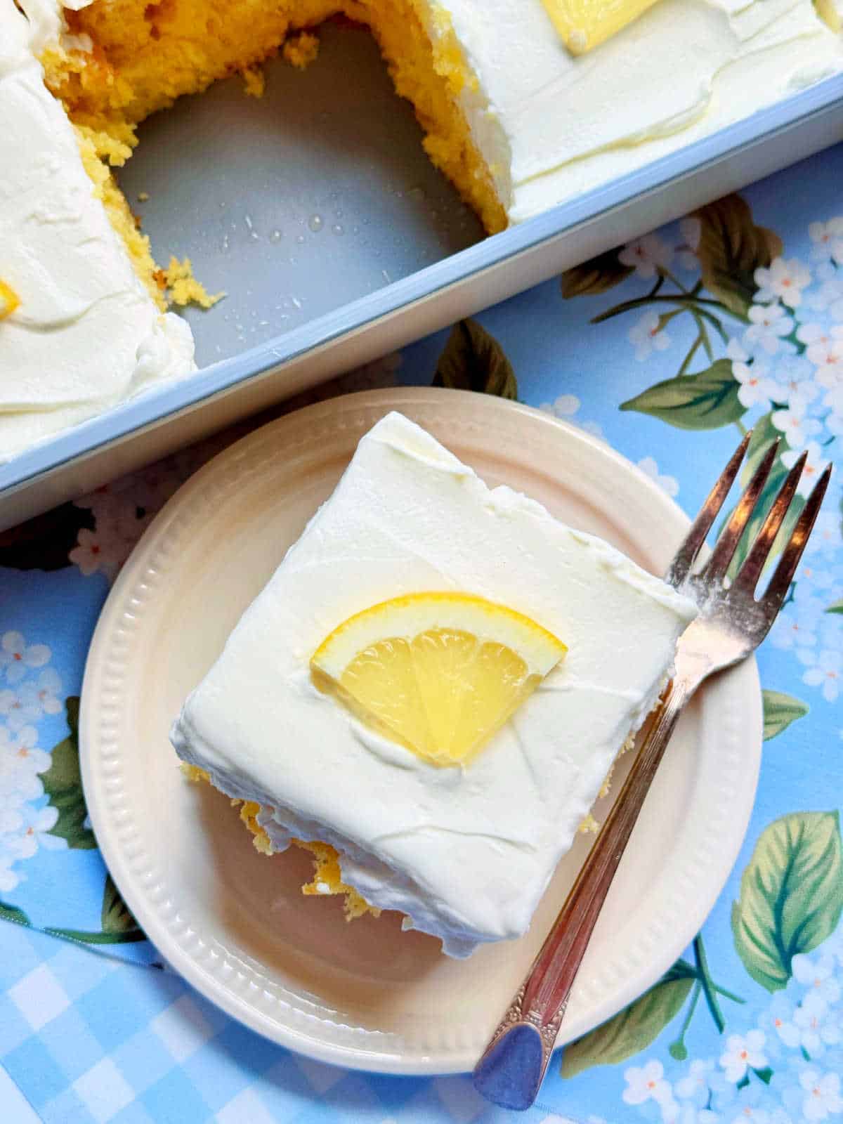 a slice of lemon poke cake on a plate ready to serve