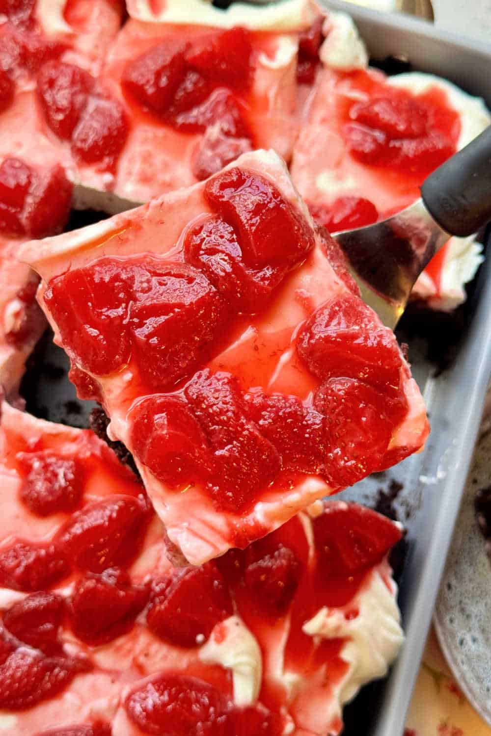 Chocolate strawberry cake starts with a tender chocolate sheet cake, topped with whipped cream cheese frosting and fresh strawberry sauce. via @foodtasticmom