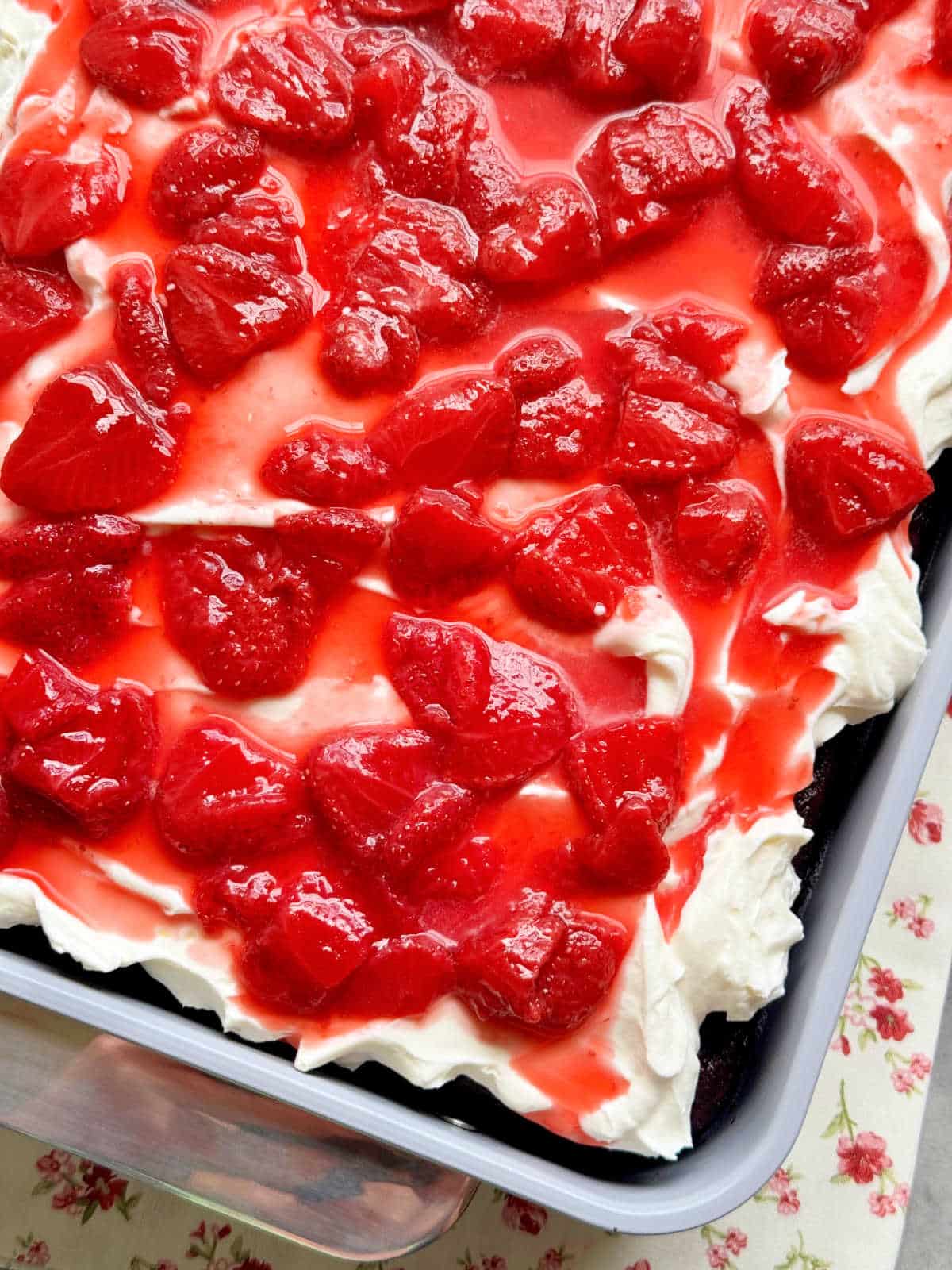 a corner picture of chocolate strawberry cake in the cake pan