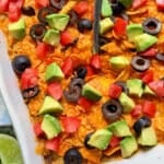 taco hash brown casserole garnished with black olives, tomatoes and avocado