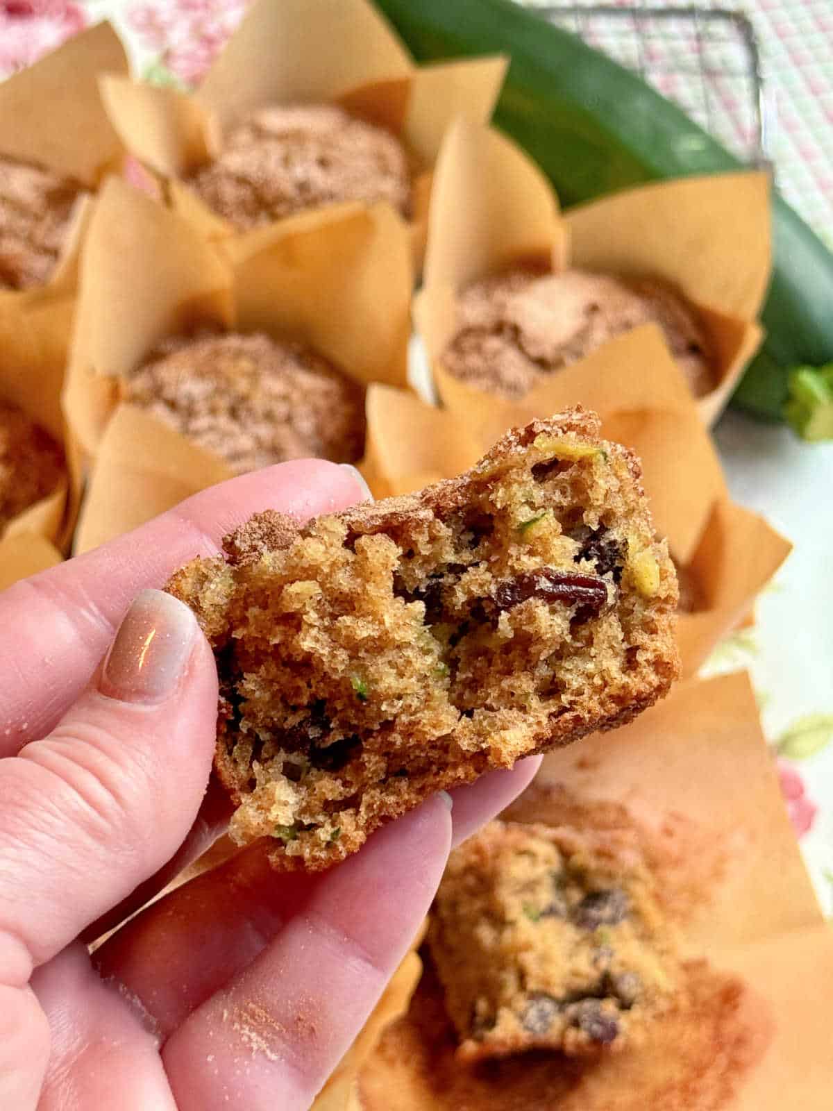 holding a zucchini muffin that's been broken in half