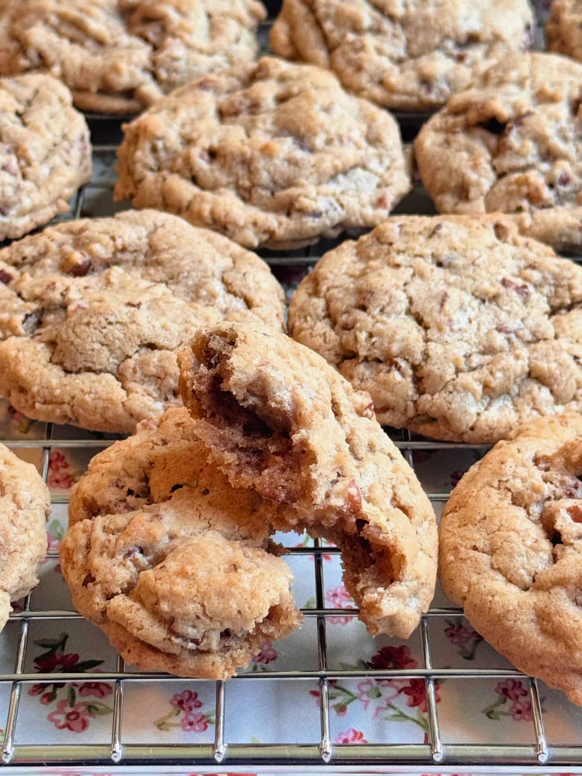 butter pecan cookies cooling on a wire rack with one broken in half to show the inside