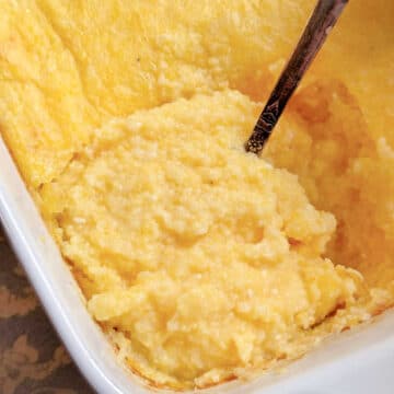 a serving of parmesan polenta ready to be spooned from the serving dish