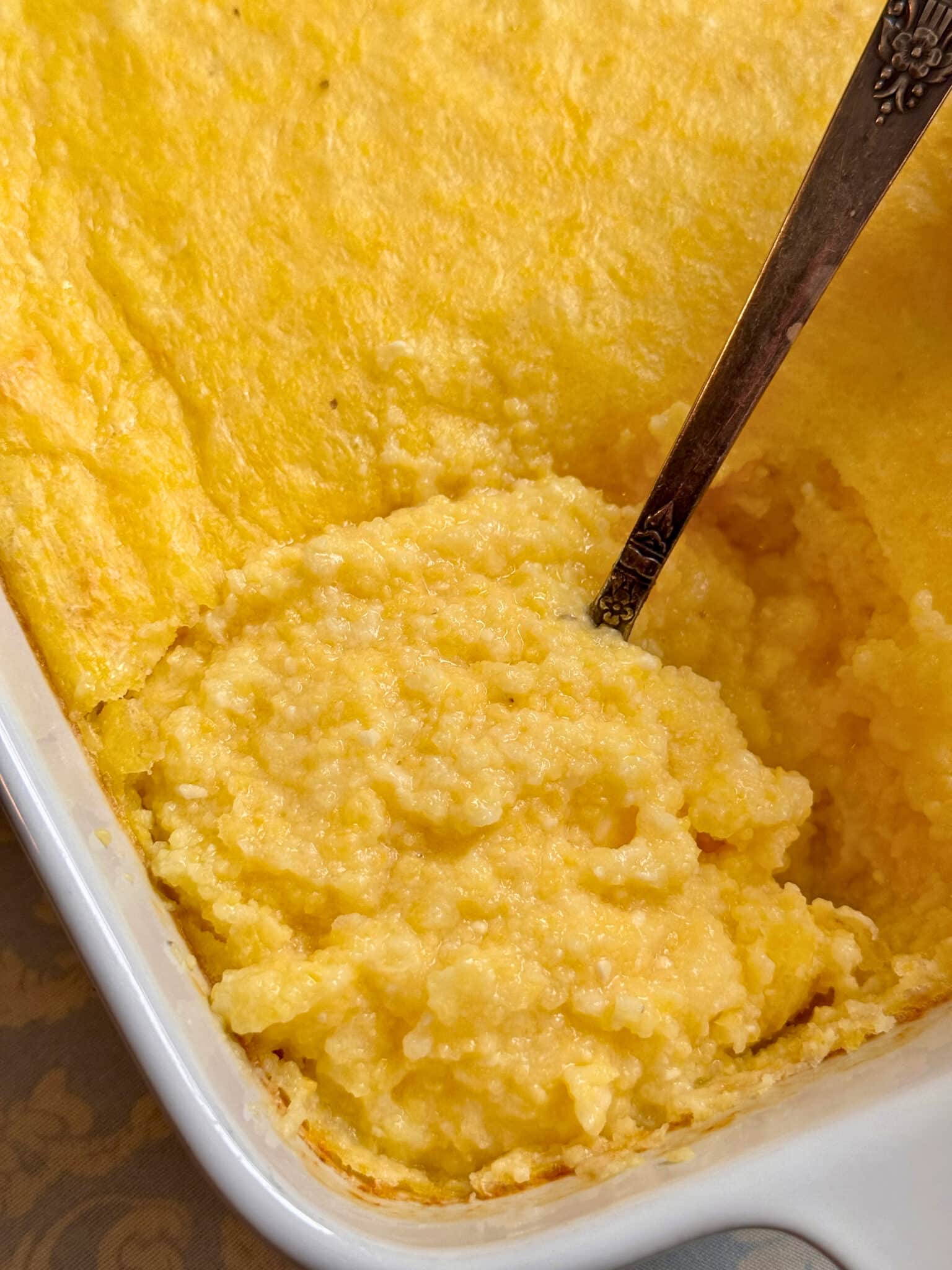 parmesan polenta stirred up with a spoon in its serving dish