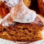 a slice of pumpkin spice latte cake topped with a dollop of whipped cream sprinkled with espresso powder