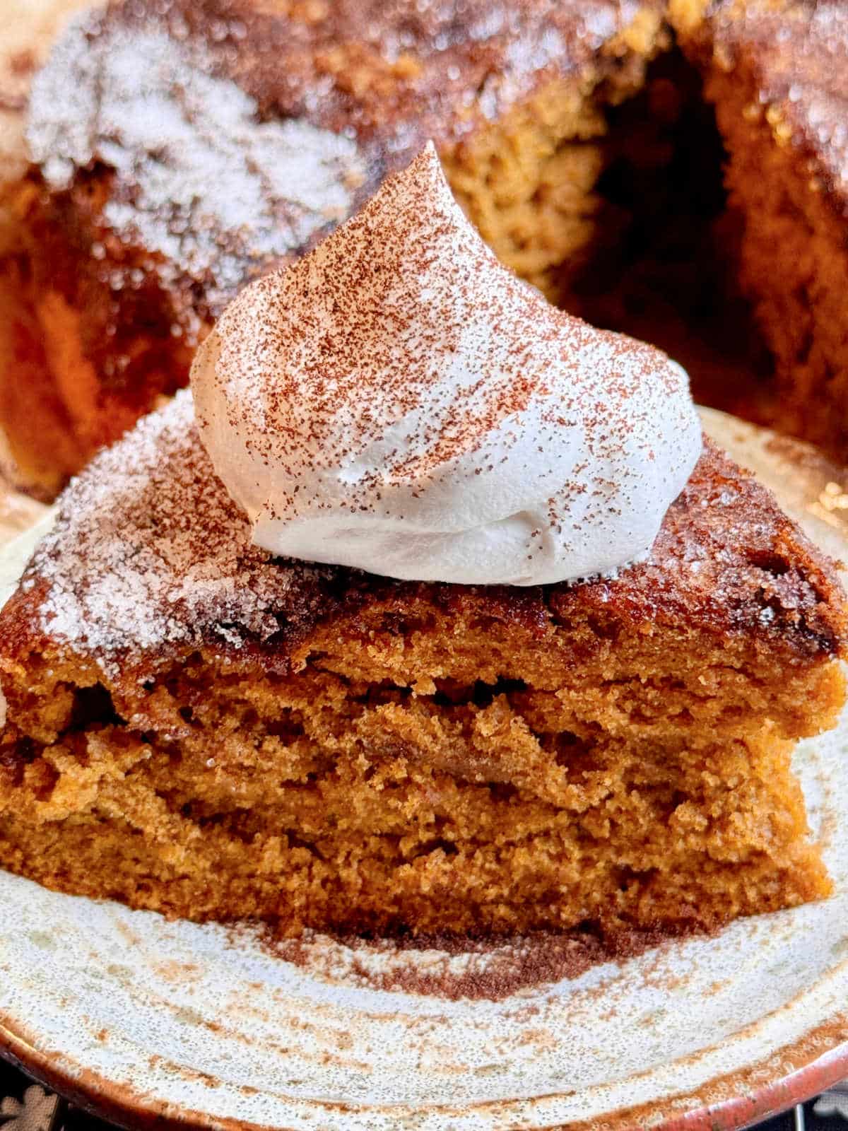 plated pumpkin spice latte cake slice topped with whipped cream