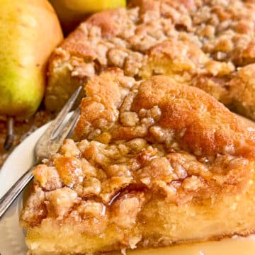 plated slice of pear cake drizzled with pure maple syrup