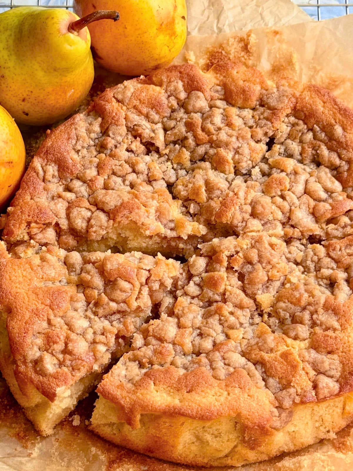 sliced pear cake with three fresh pears alongside