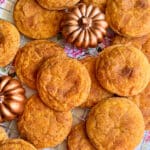 pumpkin spice cookies displayed on a wire cooling rack with some decorative small bronze pumpkins