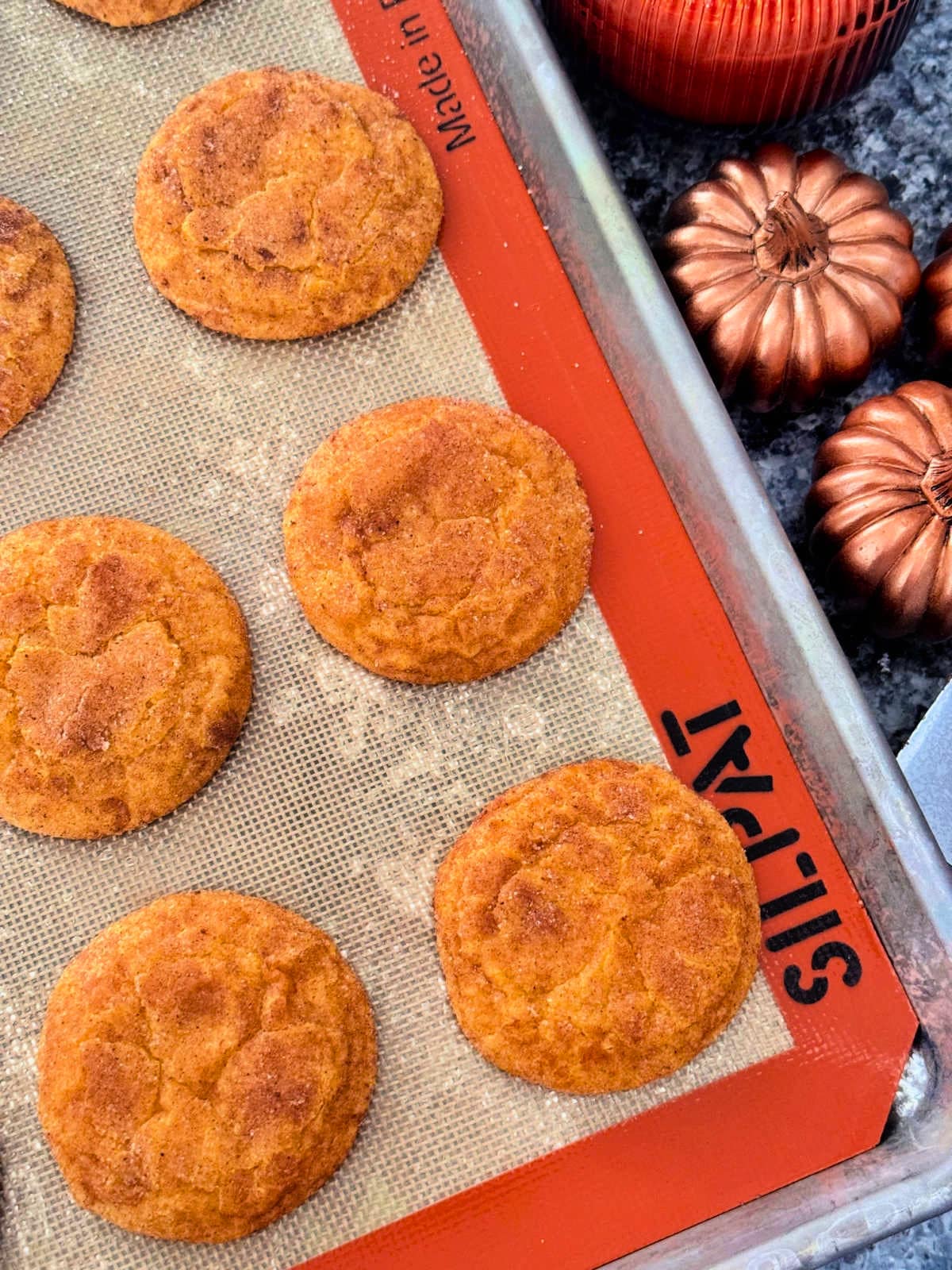 freshly baked pumpkin spice cookies on a silpat lined cookie sheet