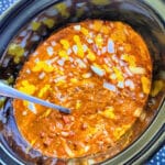 skyline chili dip garnished with mustard and onion ready to serve from the crockpot